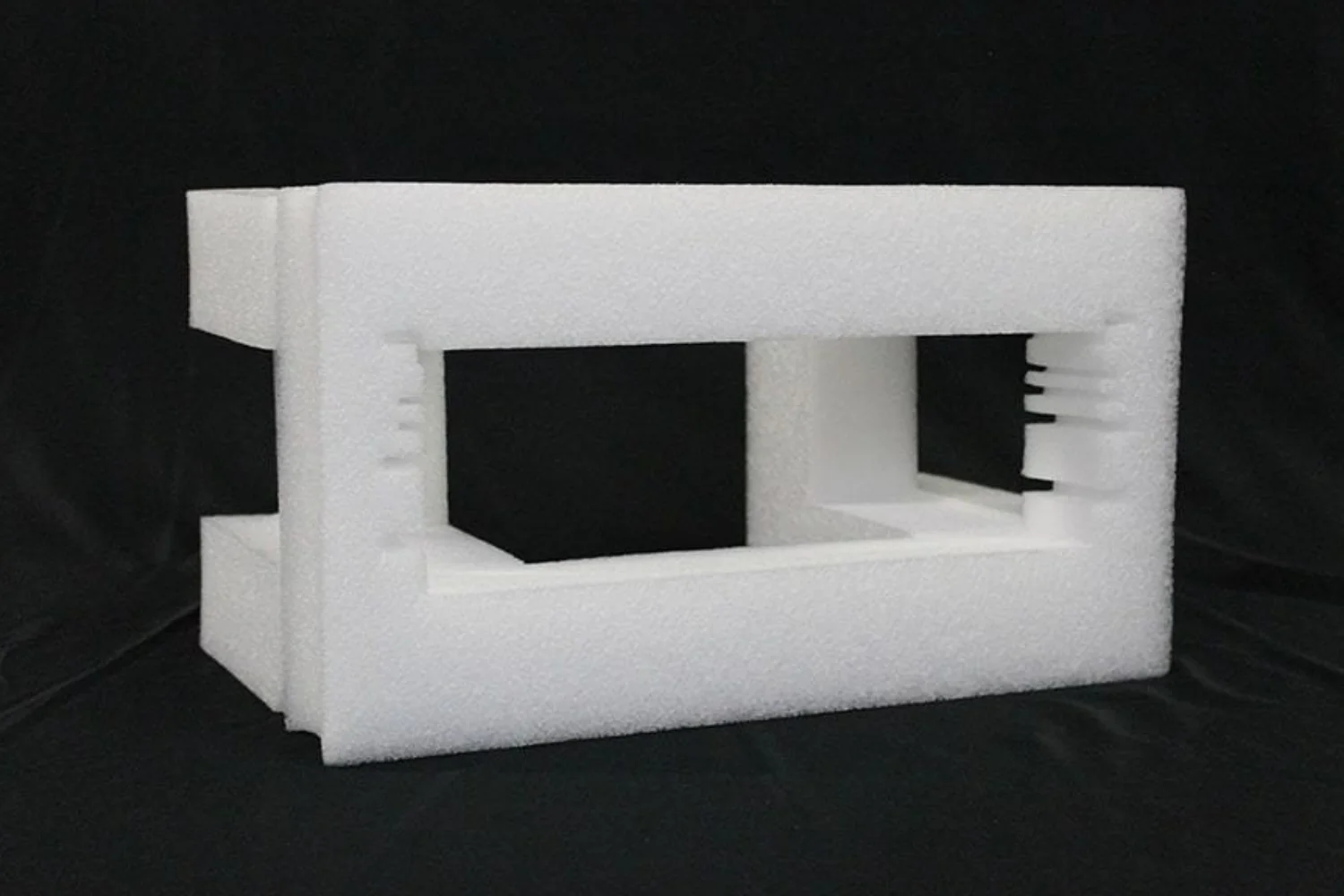 A white foam packaging container with two rectangular cutouts, designed to securely hold and protect a specific item.