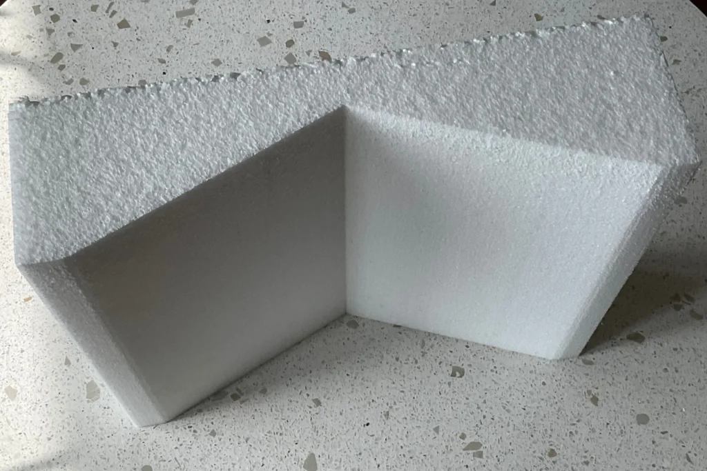 A white foam corner protector shaped like an inverted "V" to protect corners